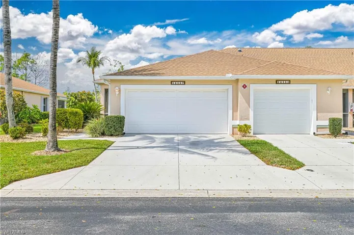 Single story home with stucco siding, a garage, and driveway