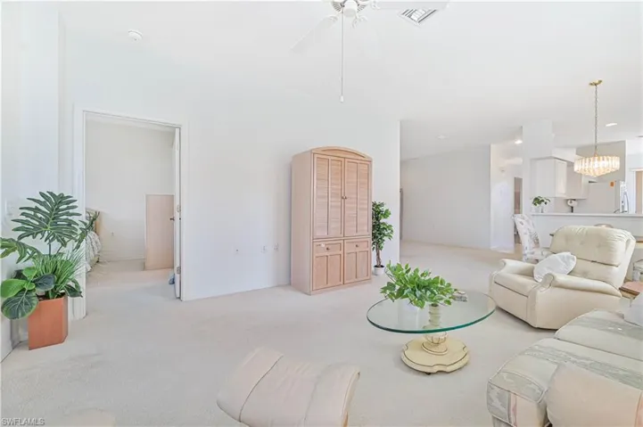 Living room featuring light carpet and a ceiling fan