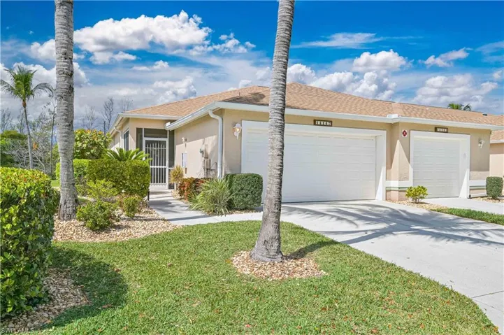 Ranch-style house with a garage, stucco siding, driveway, and a front yard