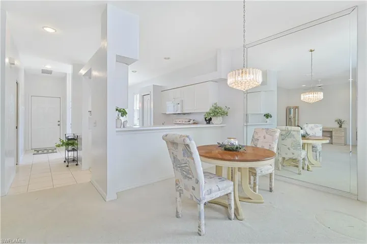Dining area with light carpet and suspended lighting