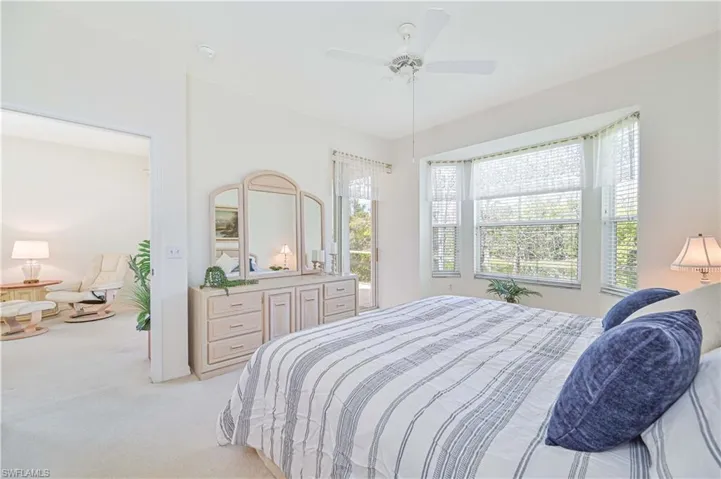 Bedroom with light colored carpet and a ceiling fan