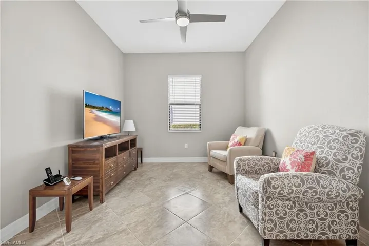 Sitting room featuring a ceiling fan and tile patterned flooring