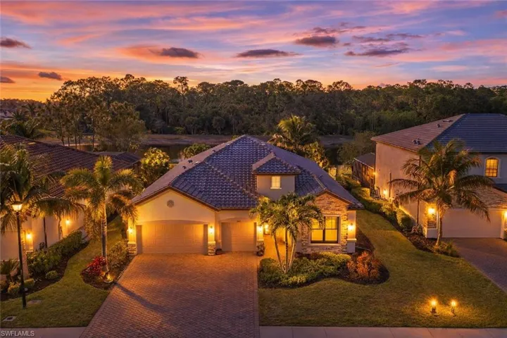 Mediterranean / spanish-style home featuring decorative driveway, a garage, stone siding, a tile roof, and stucco siding