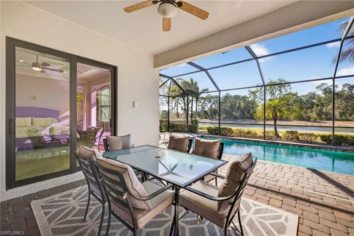 View of patio with a ceiling fan, an outdoor pool, a lanai, outdoor dining area, and a sunroom