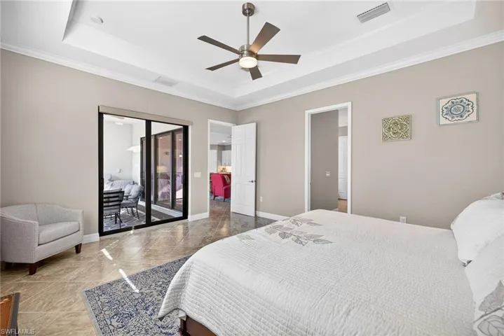 Bedroom featuring crown molding, access to exterior, a ceiling fan, and a tray ceiling