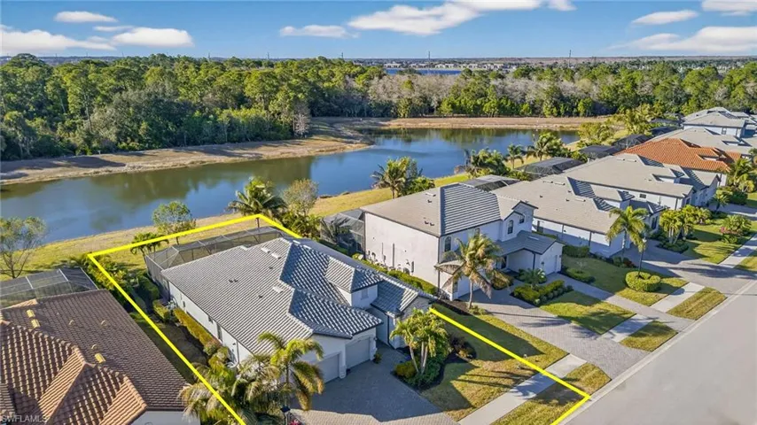 Aerial perspective of suburban area with a nearby body of water and property parcel outlined