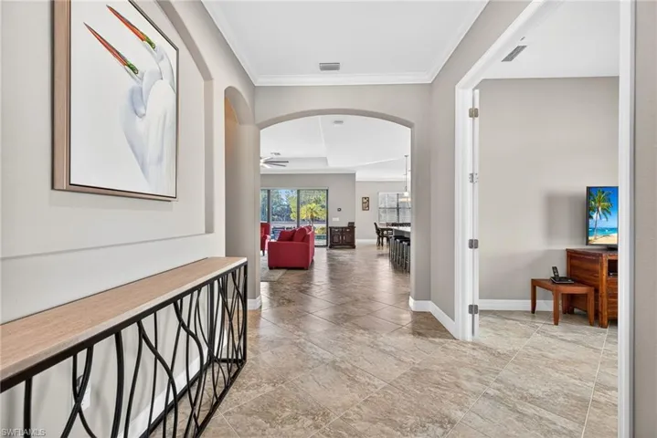 Corridor featuring arched walkways and ornamental molding