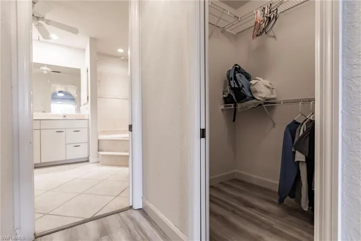 Spacious closet with ceiling fan and light hardwood / wood-style flooring