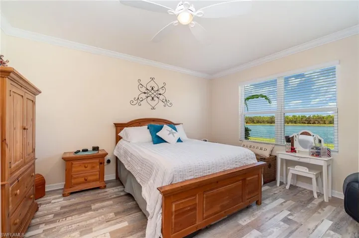 Bedroom with crown molding, light hardwood / wood-style flooring, and ceiling fan