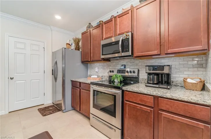 Kitchen with tasteful backsplash, appliances with stainless steel finishes