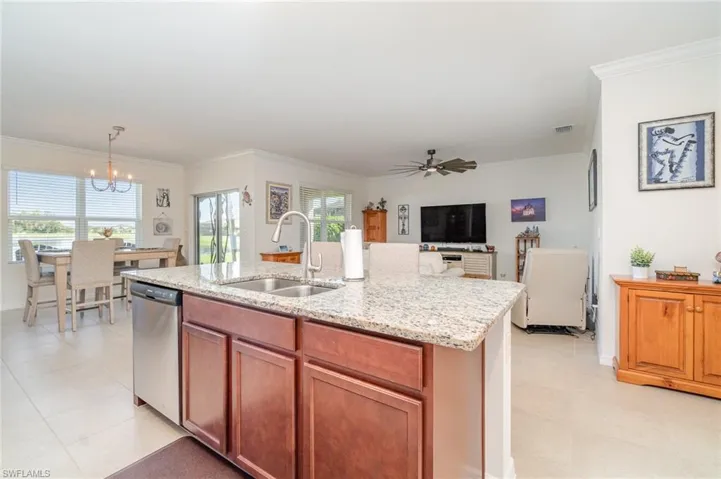 Kitchen with sink, an island with sink, ceiling fan with crown molding