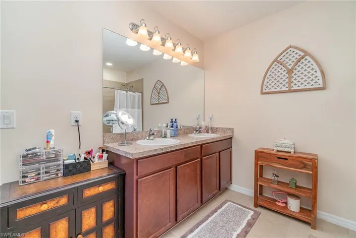 Bathroom with vanity, curtained shower, and tile patterned flooring