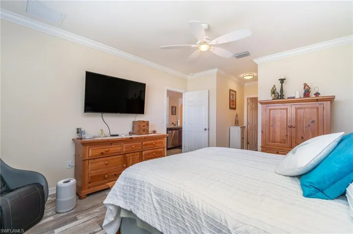 Bedroom featuring crown molding, light hardwood / wood-style flooring, and ceiling fan