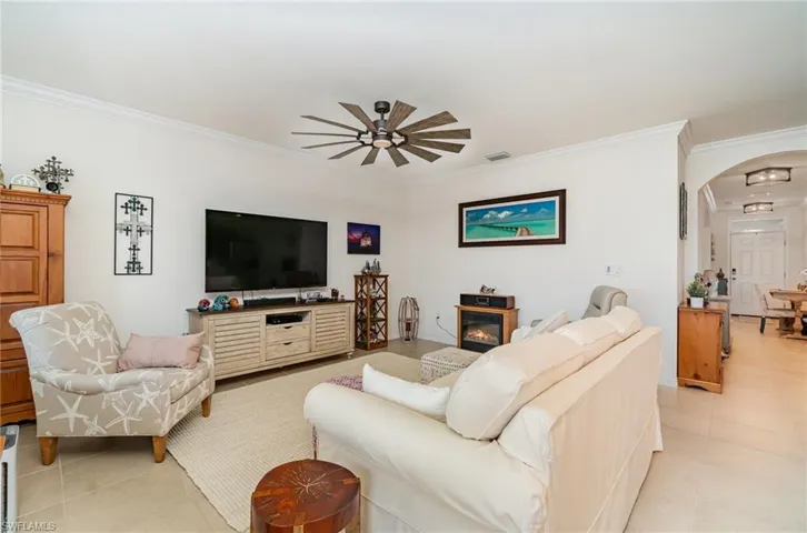 Living room with crown molding, and ceiling fan