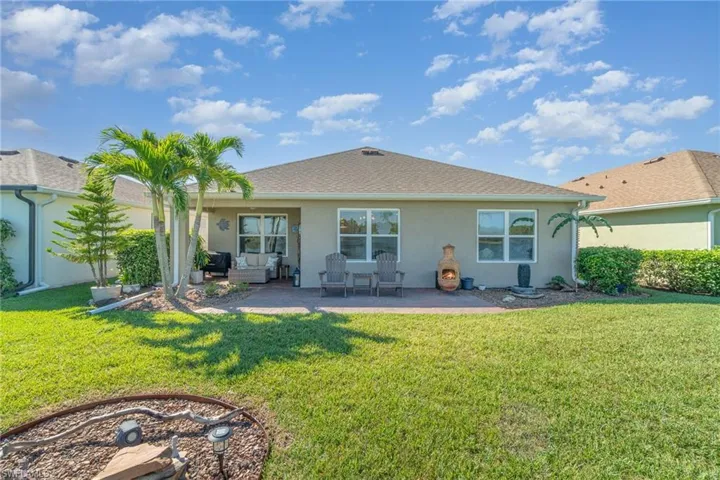 Rear view of property featuring a patio area and a lawn