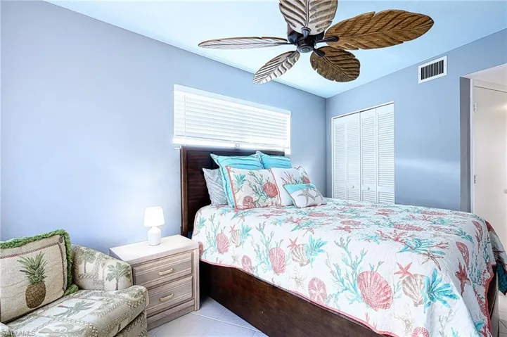 Bedroom featuring light tile patterned flooring, ceiling fan, and a closet