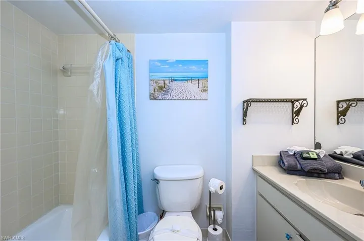 Full bathroom featuring shower / tub combo with curtain, toilet, and vanity