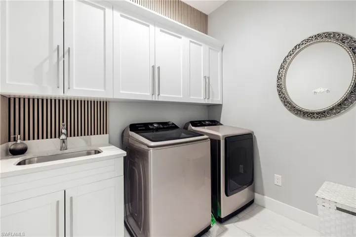 Laundry room with separate washer and dryer and cabinet space