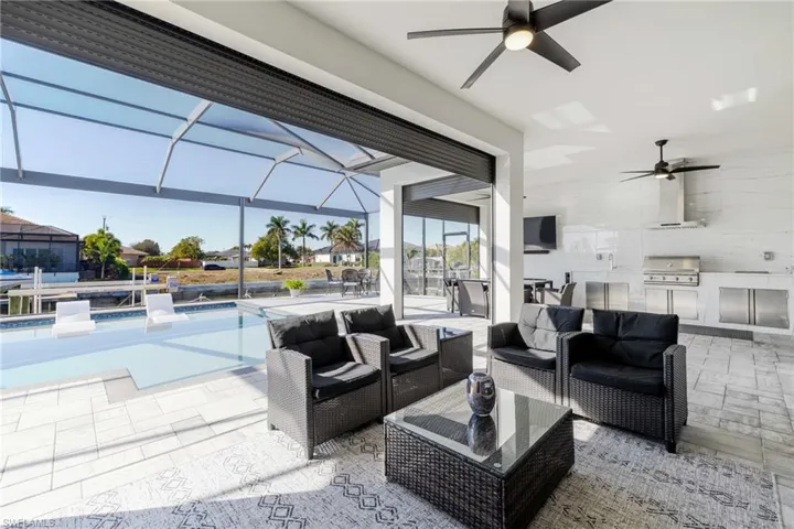 View of patio / terrace featuring a sunroom, an outdoor pool, ceiling fan, and a lanai