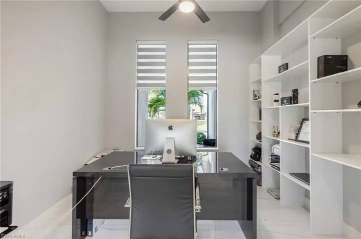 Office area with ceiling fan and baseboards