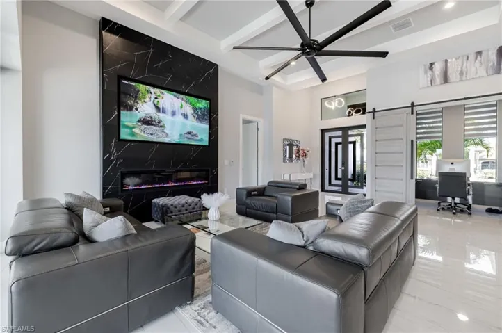 Living area featuring a desk, a ceiling fan, a barn door, and recessed lighting