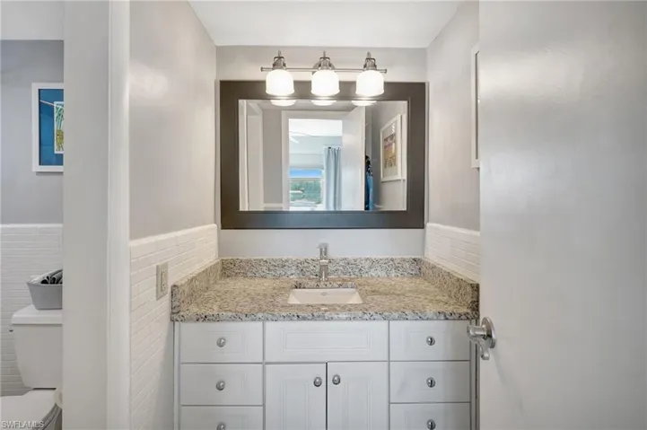 Master Bathroom with nice granite vanity, and tile walls