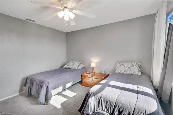 Carpeted guest bedroom with walk-in closet