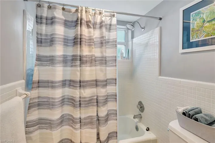 Master Bathroom with, tile walls, and shower / tub combo