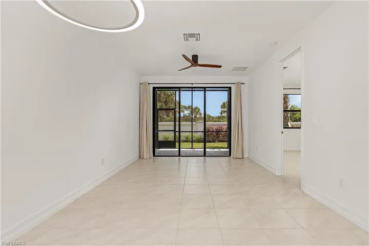 Tiled spare room featuring ceiling fan