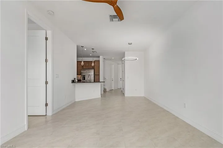 Unfurnished living room with light tile patterned flooring and ceiling fan