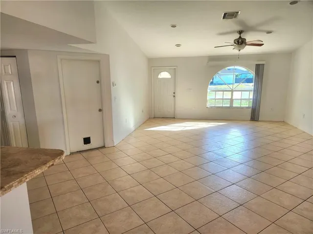 Unfurnished living room featuring ceiling fan and light tile patterned floors
