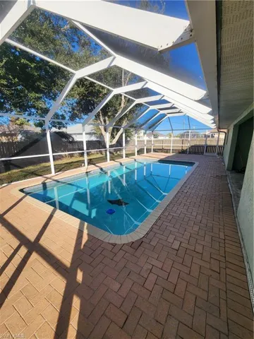 View of pool featuring a lanai, a patio, and a fenced backyard