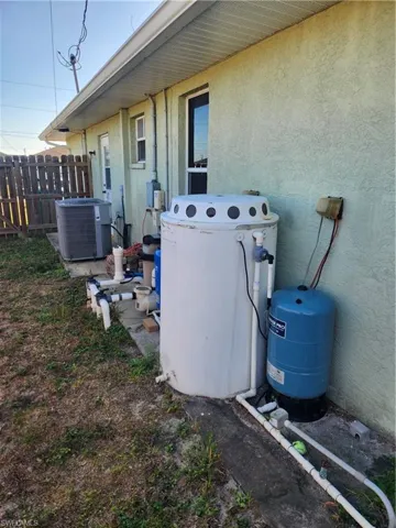 Exterior view of stucco siding and a water pressure tank