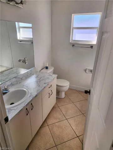 Bathroom with vanity, healthy amount of natural light, and light tile patterned floors