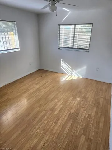 Unfurnished room featuring healthy amount of natural light, light wood-style floors, and a ceiling fan