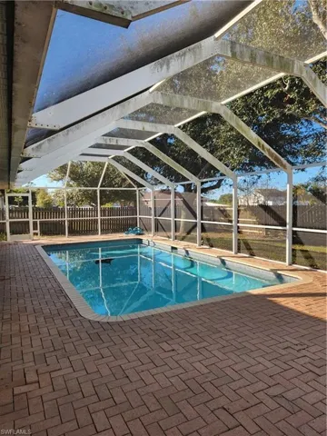 View of pool with a lanai, a fenced backyard, and a patio area