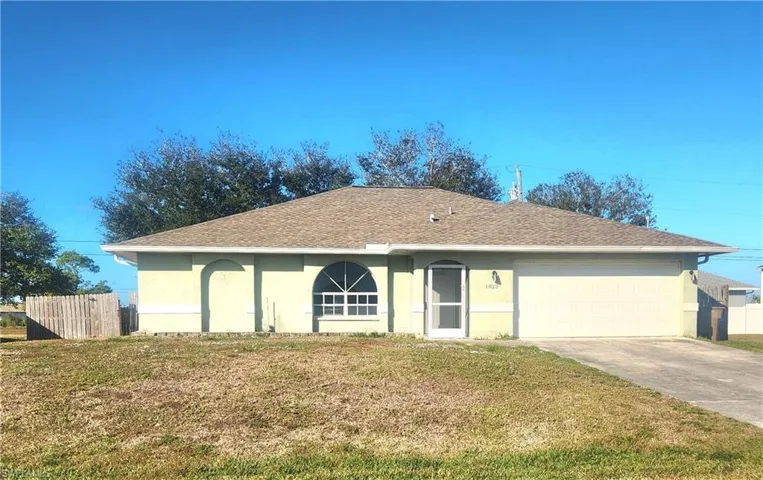 Single story home with stucco siding, concrete driveway, a shingled roof, and a garage
