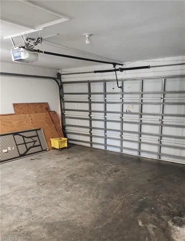 Garage featuring a garage door opener and a textured wall