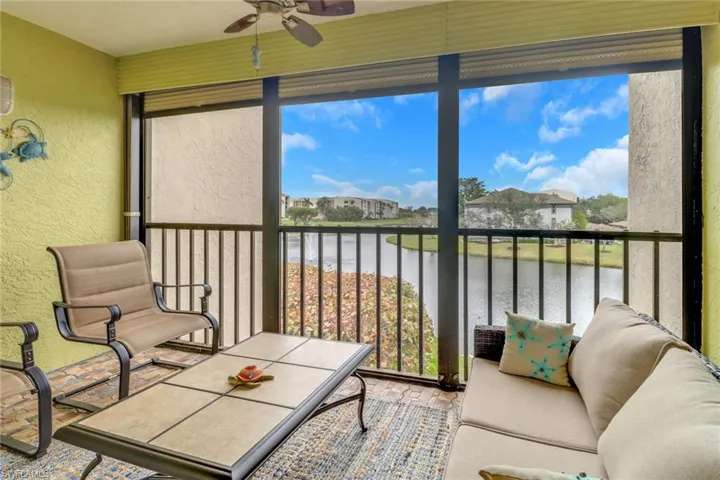 Sunroom featuring a water view and ceiling fan