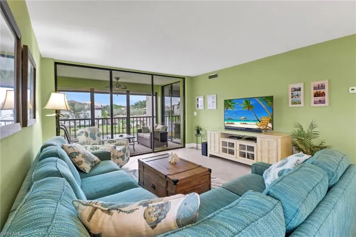 Living room with light tile patterned floors and floor to ceiling windows