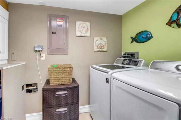Laundry room with electric panel and washing machine and dryer