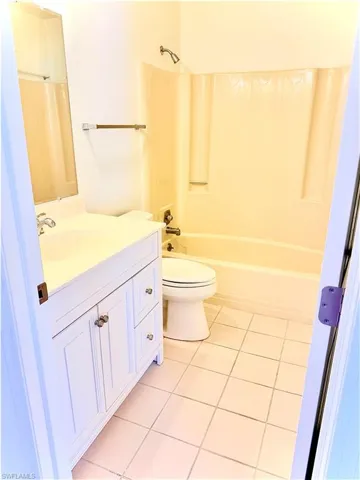 Full bathroom featuring bathing tub / shower combination, toilet, tile patterned floors, and vanity