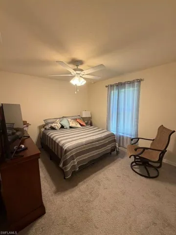Bedroom with light colored carpet and ceiling fan