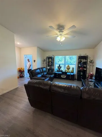 Living area with wood finished floors and a ceiling fan
