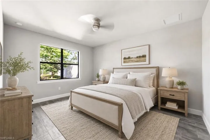 Spacious room featuring a large window with exterior landscaping, wood-finish flooring, a ceiling fan, and recessed lighting
