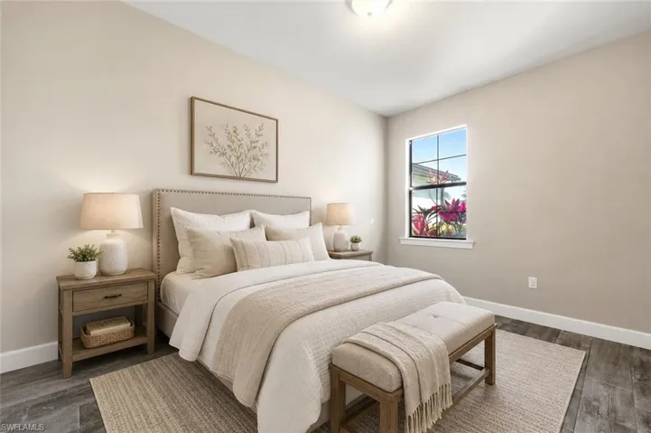 Neutral-toned room featuring wood-finish flooring, a single window with white trim, and a ceiling light fixture