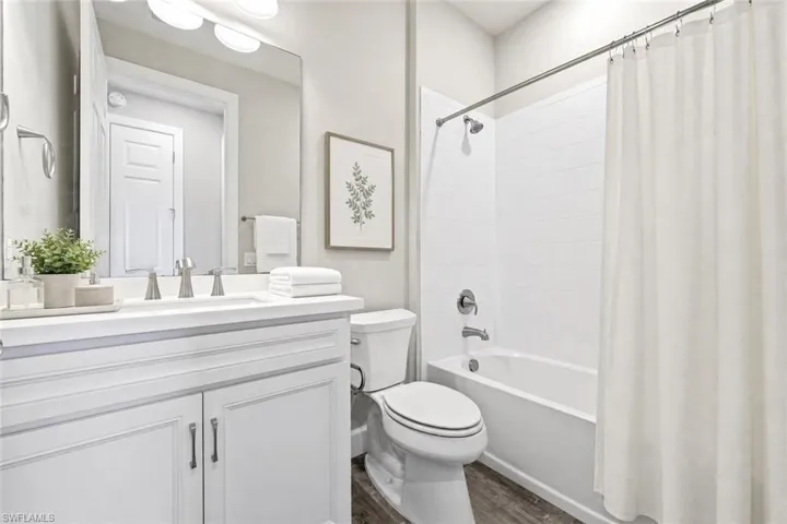 Bathroom featuring a white vanity with brushed nickel hardware, a rectangular sink, and a white countertop