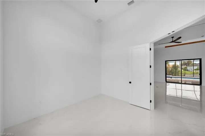 Tiled spare room featuring ceiling fan