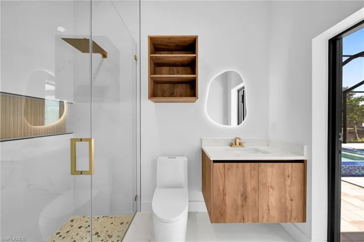 Bathroom featuring tile patterned flooring, a shower with shower door, vanity, and toilet