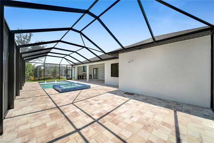 View of pool with glass enclosure and a patio
